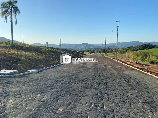 Uma estrada asfaltada atravessa uma paisagem de colinas secas.