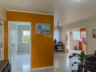 Hall de entrada com parede amarela em imóvel no Brasil.