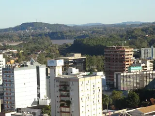 Vista panorâmica da paisagem urbana de Lajeado, Brasil, com colinas e corpos d'água ao fundo.