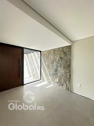 Ambiente interno com parede de pedra e porta de vidro.