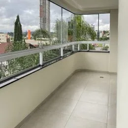 Corredor interno com vista para o exterior através de uma sacada.