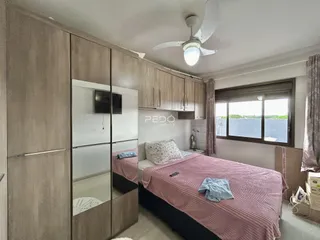 Quarto com armários em madeira e cama de casal em um imóvel no Brasil.