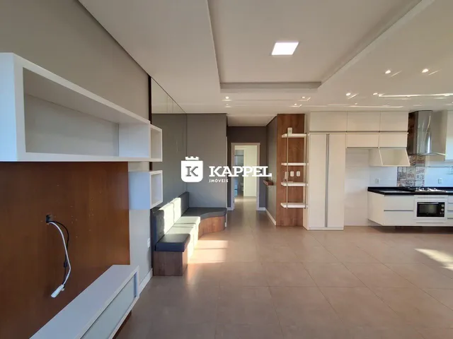 Ambiente interno moderno com sala de estar e cozinha integradas em um imóvel.