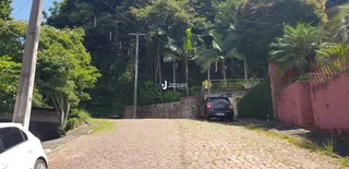 Vista externa da propriedade com muro e vegetação