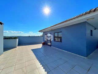 Fachada de casa com área externa pavimentada.