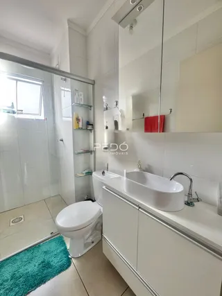 Foto interna de um banheiro moderno com piso de cerâmica e louças brancas.