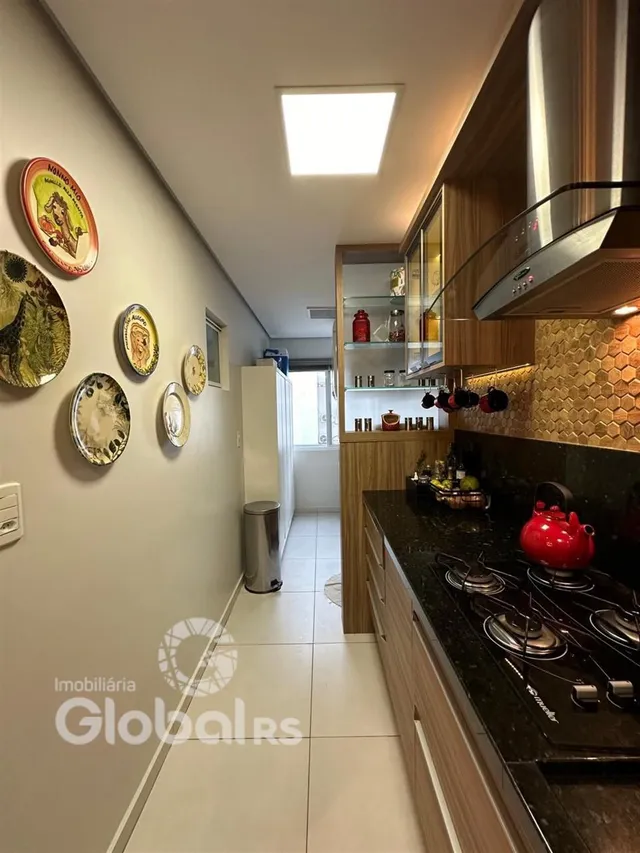 Vista interna de uma cozinha com armários de madeira e bancada escura.