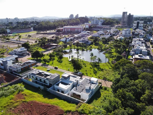 Vista aérea de uma propriedade com área verde e paisagem urbana ao fundo.