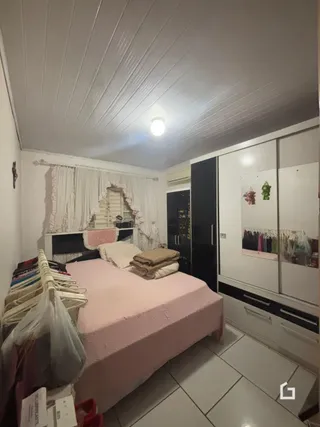 Quarto com cama e armários brancos na Lajeado.