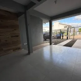 Interior de uma sala com piso de cerâmica e parede de madeira em um imóvel em Lajeado.
