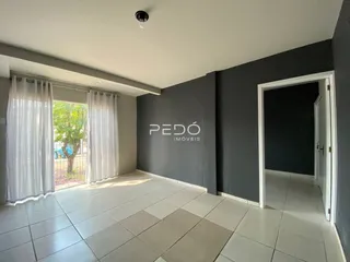 Interior de uma sala com piso de cerâmica e paredes cinzas.