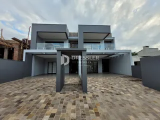 Fachada moderna de uma residência com área externa pavimentada.