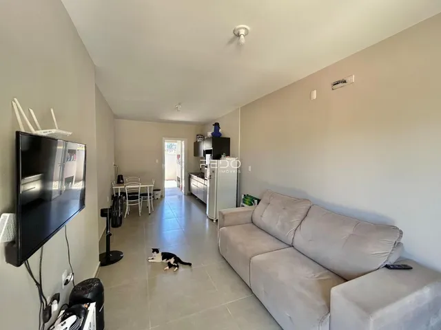 Sala de estar com sofá e acesso à cozinha em um imóvel em Lajeado.