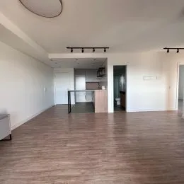 Ambiente interno amplo com piso de madeira clara.