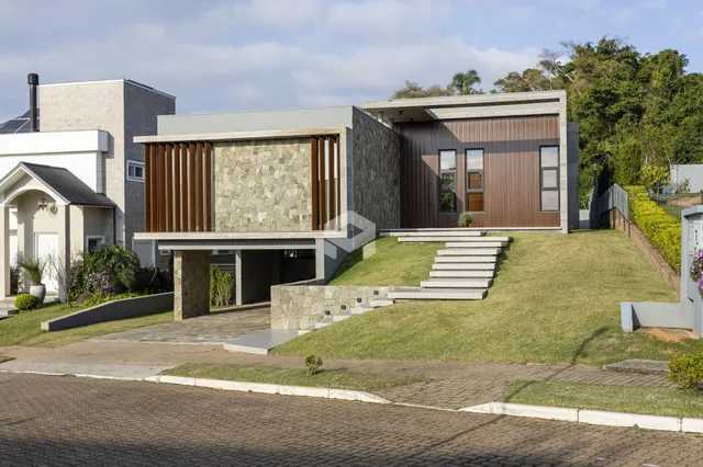 Fachada moderna de uma casa em Lajeado, Brasil, com jardim gramado e degraus.