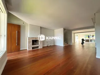 Foto interna de uma sala com piso de madeira polida.