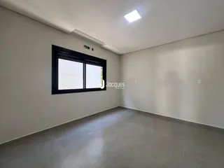 Foto de uma sala de estar com paredes brancas e piso cinza.