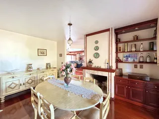 Foto de uma sala de jantar com móveis de madeira e lareira.
