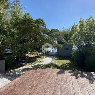 Vista externa de uma residência com jardim e deck.