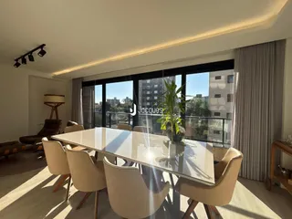 Sala de jantar com vista para a cidade através de grandes janelas.