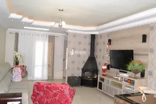 Sala de estar com lareira e sofá de cor vermelha.