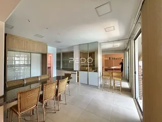 Vista de uma sala de jantar com móveis de vime e piso de cerâmica.