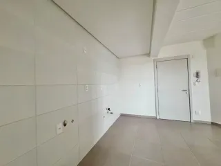 Vista interna de um corredor com paredes brancas e piso de cerâmica.