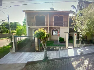 Fachada de uma casa em Lajeado, Brasil, com cerca e jardim na frente.
