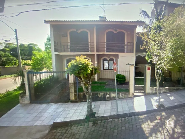 Fachada de uma casa em Lajeado, Brasil, com cerca e jardim na frente.