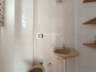 A foto mostra o interior de um banheiro com azulejos brancos.
