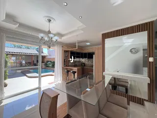 Sala de estar com portas de vidro que dão acesso a uma área externa com piscina.