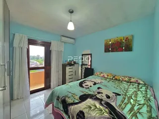 Quarto com cama e janela em uma residência no Brasil.