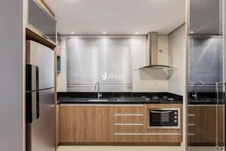 Cozinha moderna com armários de madeira e eletrodomésticos de aço inoxidável.