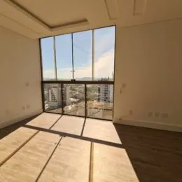 Vista externa através de grandes janelas de uma sala.