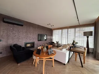 Sala de estar moderna com lareira e grandes janelas em Lajeado.