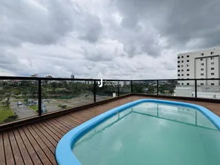 Vista de uma piscina em um terraço com vista para a cidade.