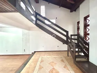 Foto de uma área interna com escadaria e piso de cerâmica.