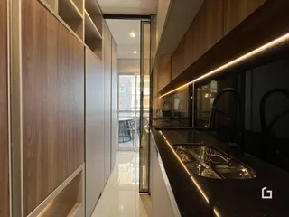 Vista de um corredor moderno com armários de madeira e bancada de cozinha.