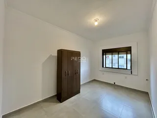 Interior de um cômodo com paredes brancas e piso claro.