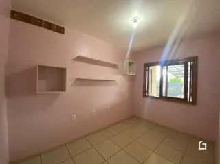 Hall de corredor com paredes rosa e piso de cerâmica.