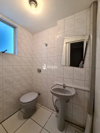 Foto de um banheiro com piso de cerâmica e azulejos brancos.