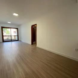 Vista interna de um ambiente com piso de madeira clara.