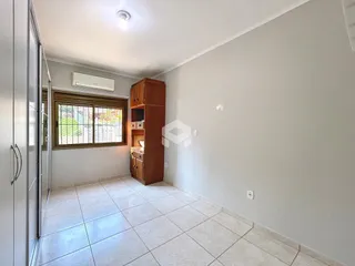 Foto de uma sala de estar com piso de cerâmica e armário de madeira.