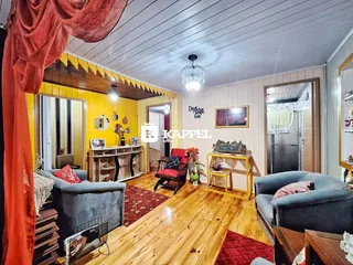 A sala de estar apresenta piso de madeira e decoração rústica.