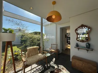 Sala de estar com grande janela de vidro voltada para o jardim.