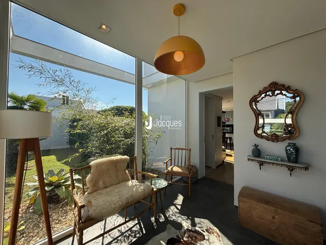 Sala de estar com grande janela de vidro voltada para o jardim.
