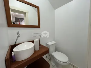 Foto de um banheiro com pia e vaso sanitário em madeira.