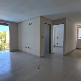 Hall de entrada com paredes brancas e piso claro.