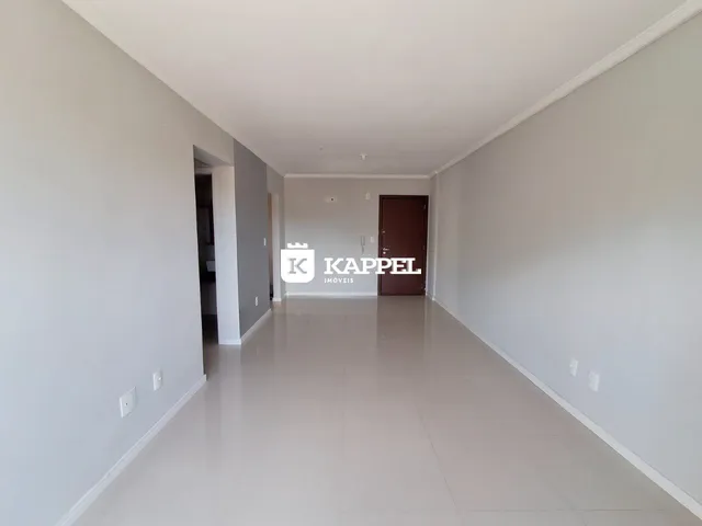 Foto de um corredor interno de uma residência com paredes brancas e piso claro.