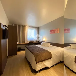 Quarto com cama de casal e piso de madeira em um imóvel no Brasil.